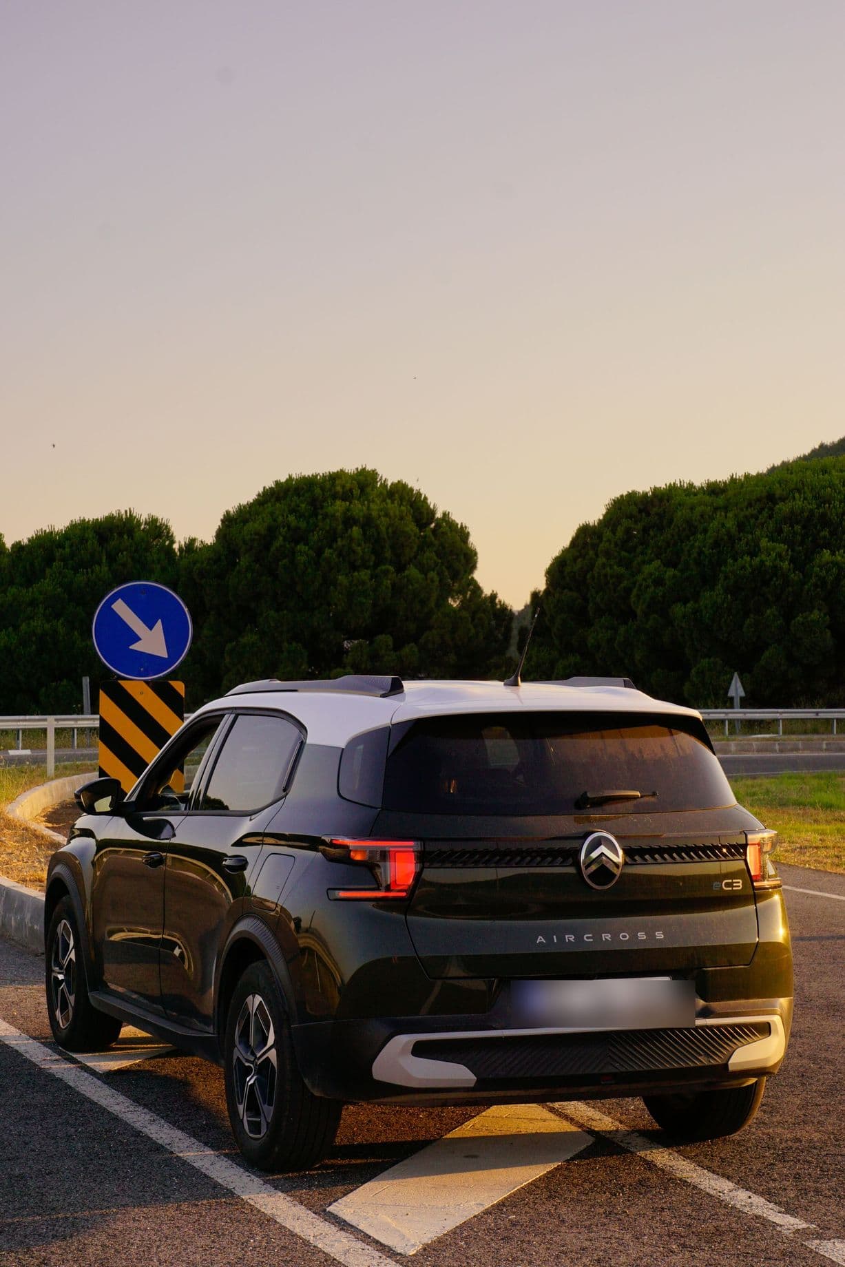Rear of a dark Citroën ë-C3 Aircross parked at sunset